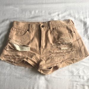 Peach colored shorts with rips
